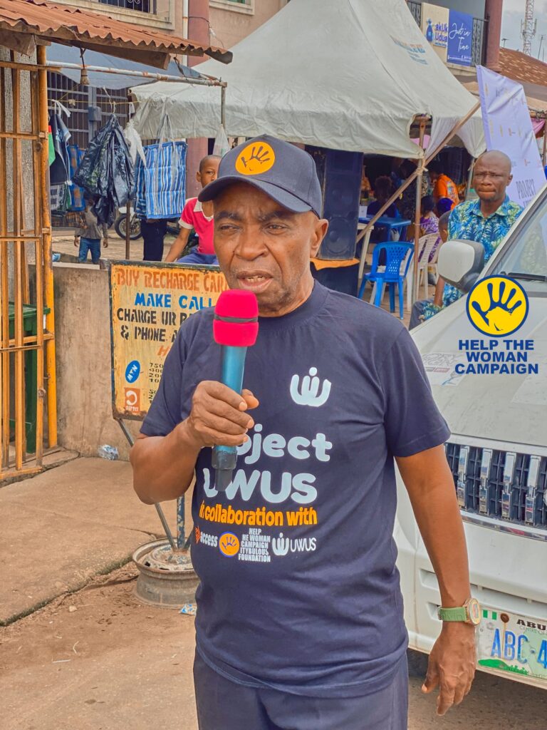 A Project UWUS campaigner speaking into a microphone on a market street