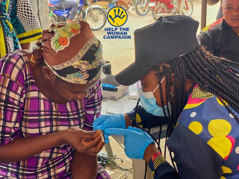 A health worker testing a woman's blood sugar