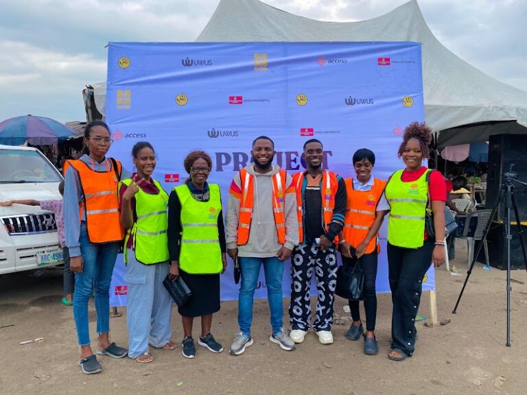 Project UWUS volunteers in high-visibility vests at the campaign banner