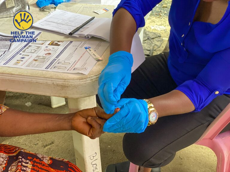 A health worker carrying out a test at a Help The Woman Campaign market outreach