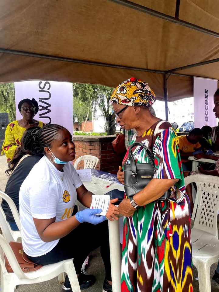 A health worker attending to a woman under a Project UWUS outreach tent